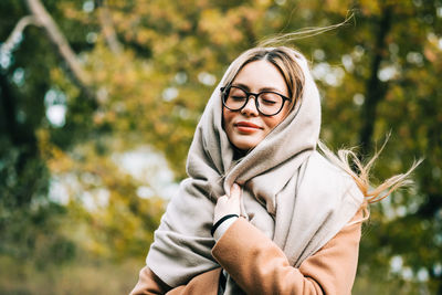 Portrait of smiling young woman against plants