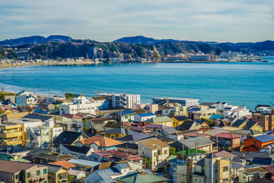 High angle view of townscape by sea against sky