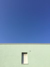 Low angle view of building against clear blue sky