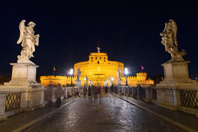 Statue of illuminated historic building at night