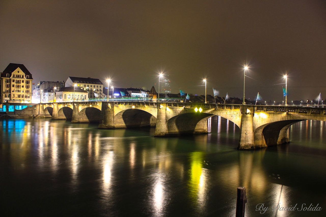 bridge - man made structure, connection, architecture, water, river, transportation, city, travel destinations, built structure, reflection, travel, illuminated, night, arch, waterfront, metal, outdoors, building exterior, cityscape, no people, sky, astronomy