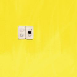 Close-up of light switch on yellow wall