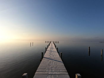 Pier over lake against clear sky