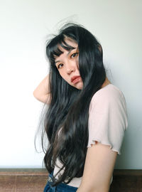 Portrait of young woman against white background