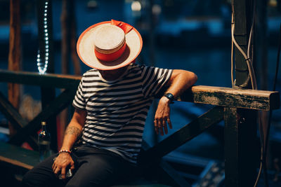 Man sitting in city at night