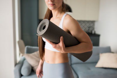 Close up of woman holding thick mat fitness and exercise. classic yoga mat 