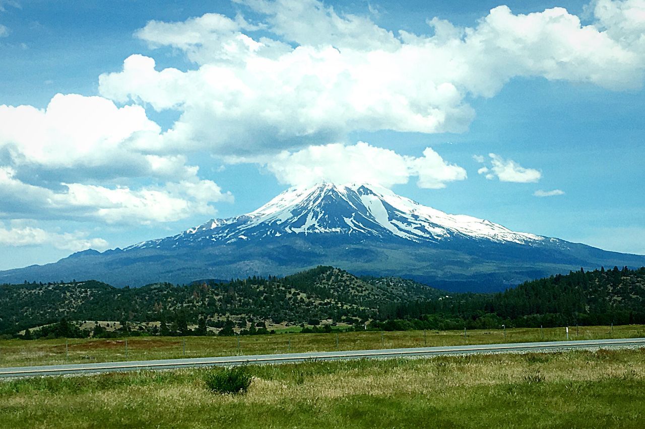 mountain, tranquil scene, scenics, landscape, tranquility, mountain range, travel destinations, beauty in nature, non-urban scene, majestic, road, sky, tourism, nature, cloud - sky, idyllic, mountain peak, physical geography, remote, day, green color, blue, outdoors, geology, famous place, vacations, natural landmark, countryside