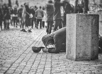 Man begging on footpath in city