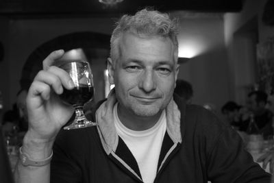 Portrait of smiling man holding wineglass in restaurant