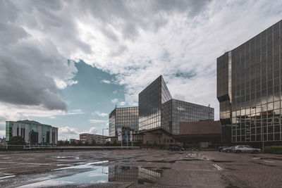 Buildings by road against sky in city