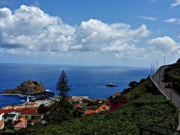 High angle view of town by sea against sky