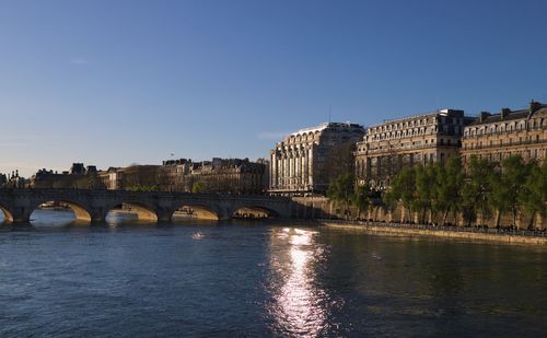 Bridge over river against buildings in city