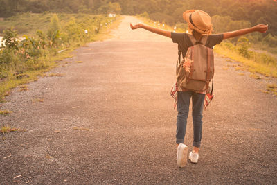 Rear view of woman walking on road