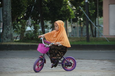 Portrait of young woman riding bicycle on street