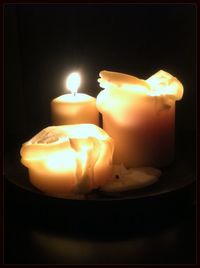 Close-up of illuminated candle against black background