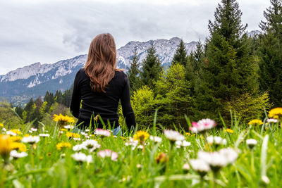 Rear view of woman standing amidst plants