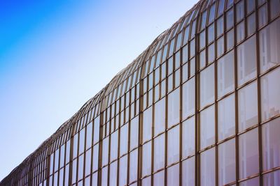 Low angle view of glass building against sky