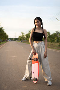 Portrait of woman standing on road against the sky