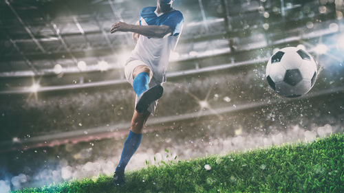 Man playing soccer ball in rain