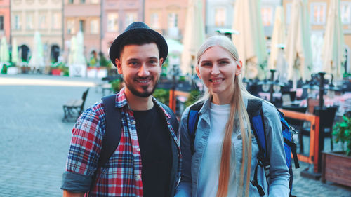 Portrait of smiling friends standing in city