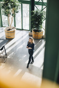 Business professional using smart phone in office corridor