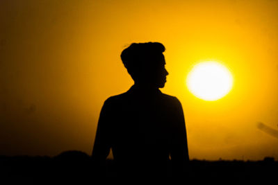 Silhouette man standing against sky during sunset