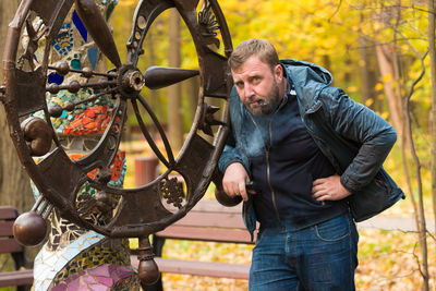 Portrait of mature man standing by metal structure