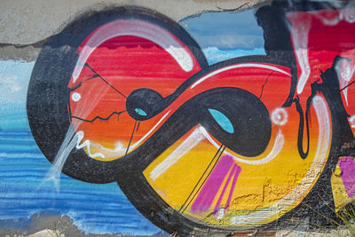 Close-up of multi colored graffiti on wall