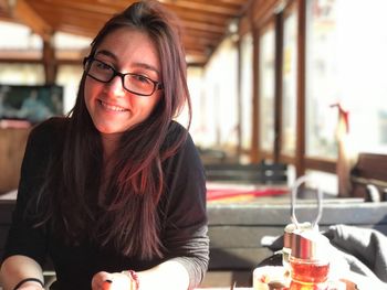 Portrait of smiling young woman sitting at restaurant