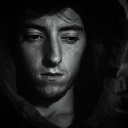 Close-up of serious young man black background