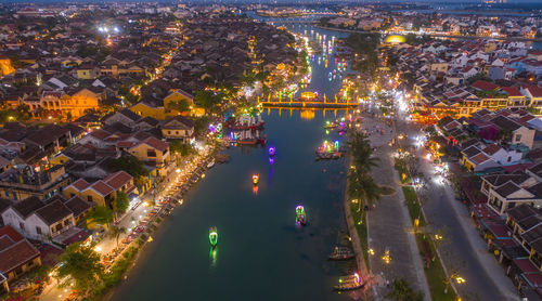 High angle view of illuminated street amidst buildings at night