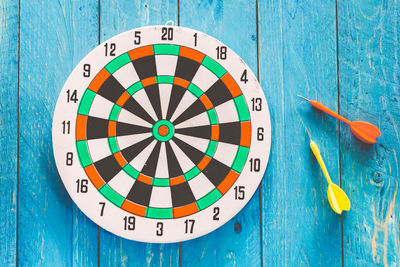 Close-up of arrows and dartboard on table