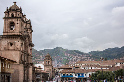 Buildings in city against cloudy sky