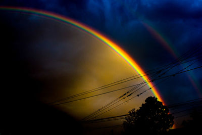 Low angle view of rainbow against sky during sunset