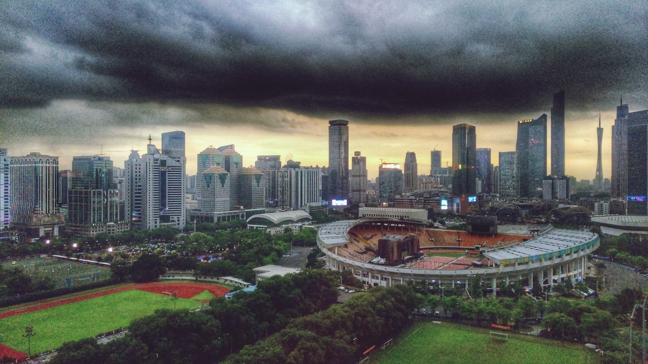 building exterior, architecture, built structure, city, cityscape, sky, cloud - sky, cloudy, skyscraper, high angle view, tree, weather, urban skyline, overcast, tower, residential building, residential district, modern, growth, city life