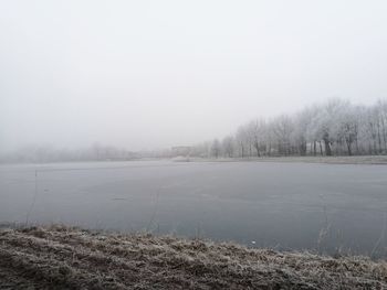 Scenic view of lake against sky during winter