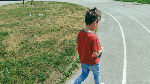 Rear view of boy walking on road