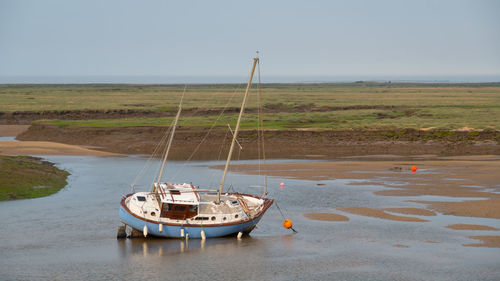 Boat moored on sea against clear sky