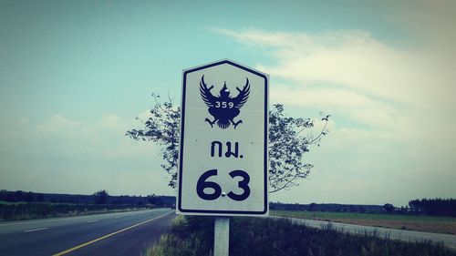 Road sign against sky