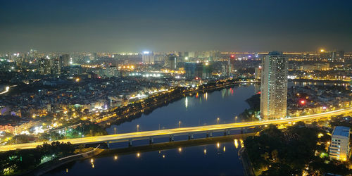 High angle view of illuminated bridge over river against sky at night