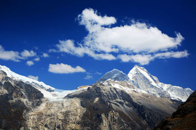 Scenic view of snow covered mountains against blue sky