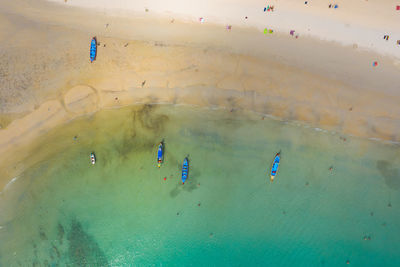Aerial view or top view of long-tailed boat is floating on  sea at phuket, thailand. kata beach