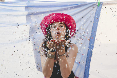 Portrait of woman blowing confetti