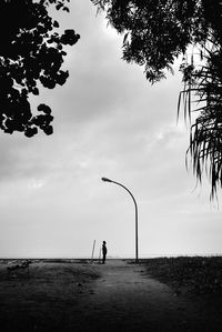 Silhouette men on beach against sky