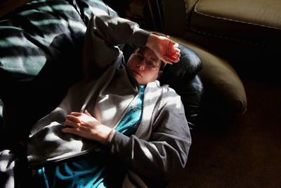 High angle view of woman lying on sofa at home