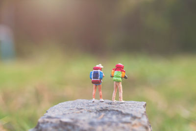 Miniature people backpackers walking with friends 