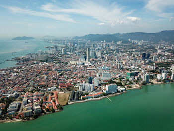 High angle view of city by sea against sky