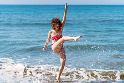 Rear view of woman standing at beach