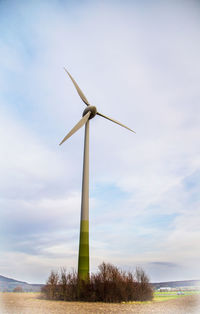 Low angle view of windmill on field against sky