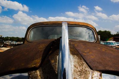 Close-up of rusty car against sky